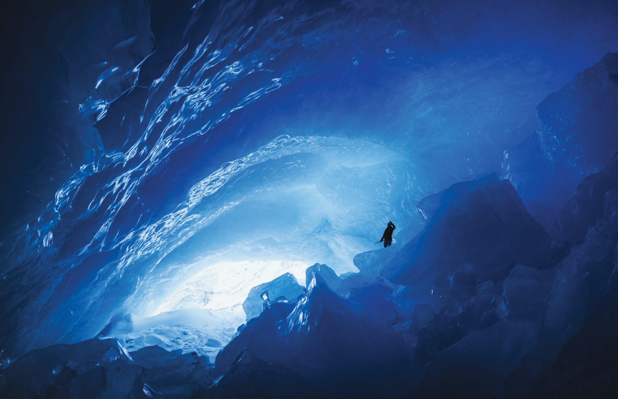 An ice cave lit by a headlamp in the magical world of snow and ice