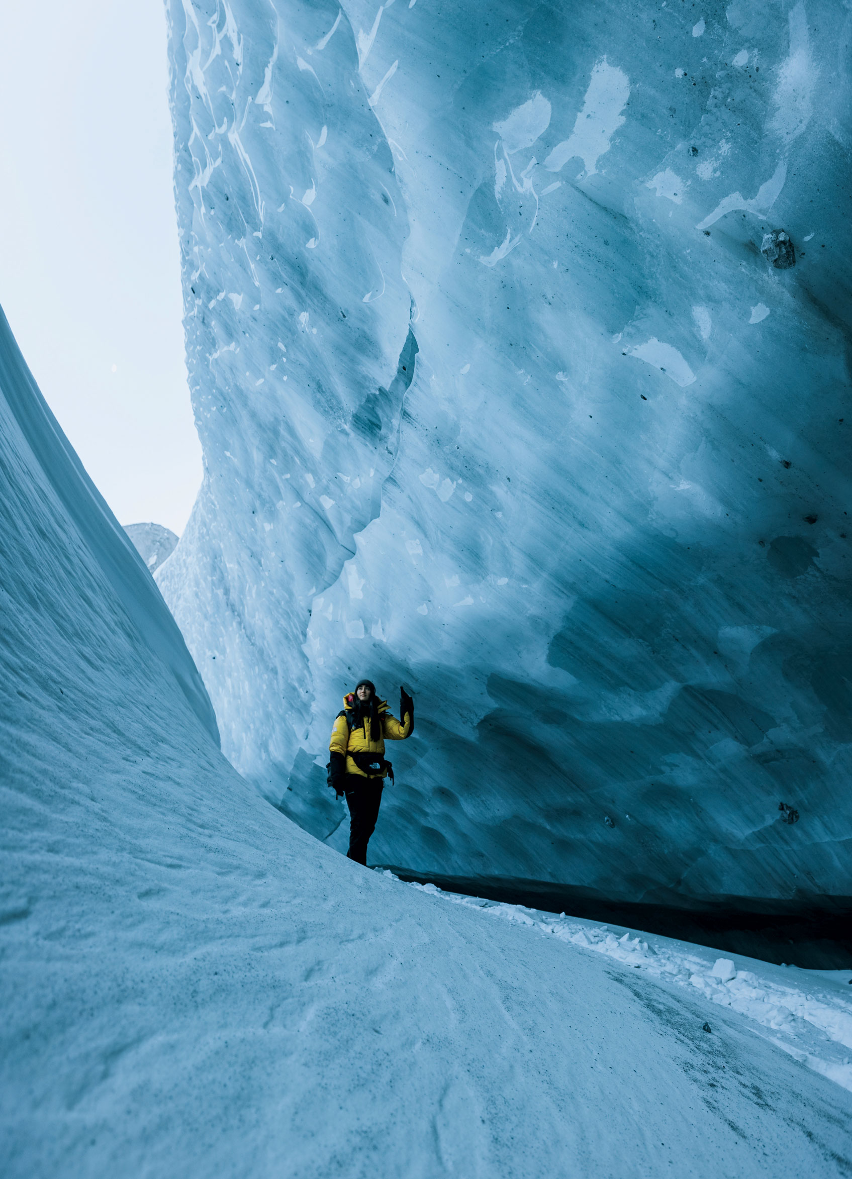 A person walks in a deep ice crevice