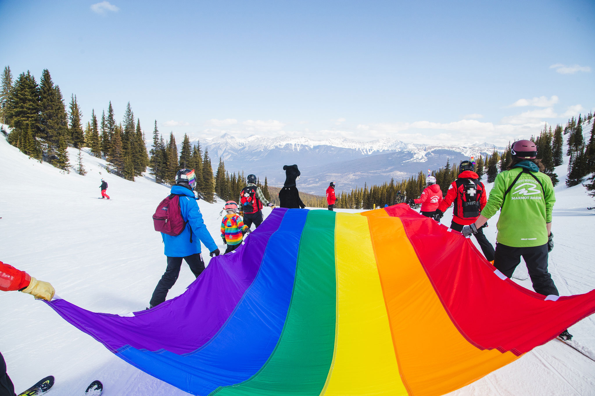 Skiing behind the giant pride flag at Marmot Basin
