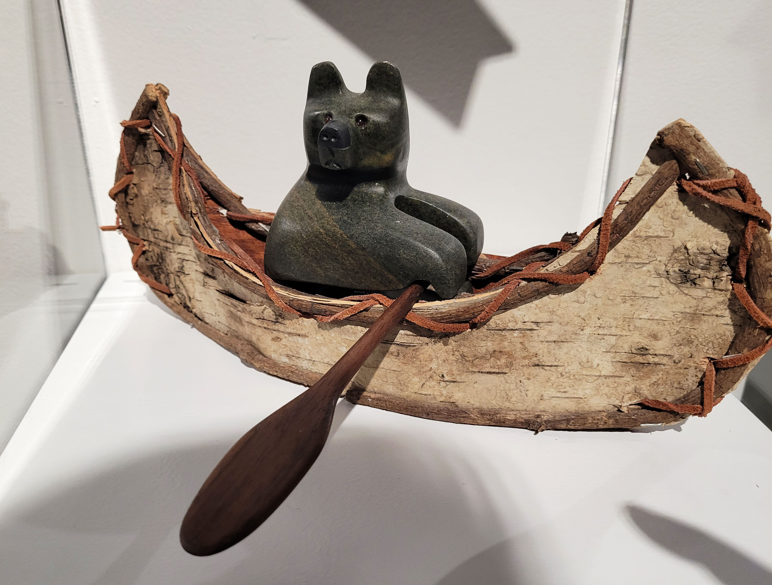 Down the River / Bear in a Birch Bark Canoe by Vance Theoret. Birch bark and soapstone. Part of the McCreath Collection on display at the Whyte Museum of the Canadian Rockies. 
