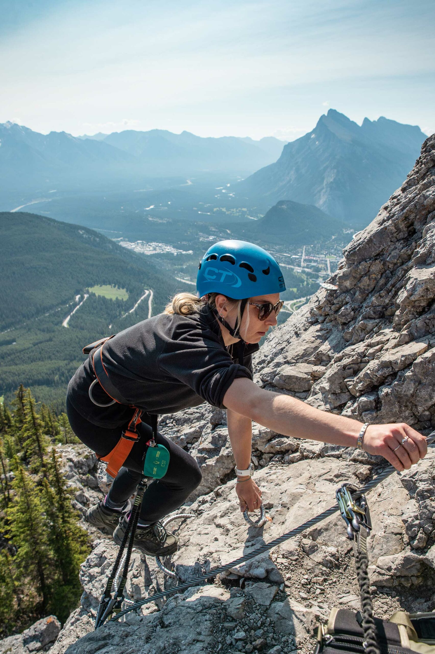 A person climbs on the Via Ferrata at Mount Norquay with great views in the background. 