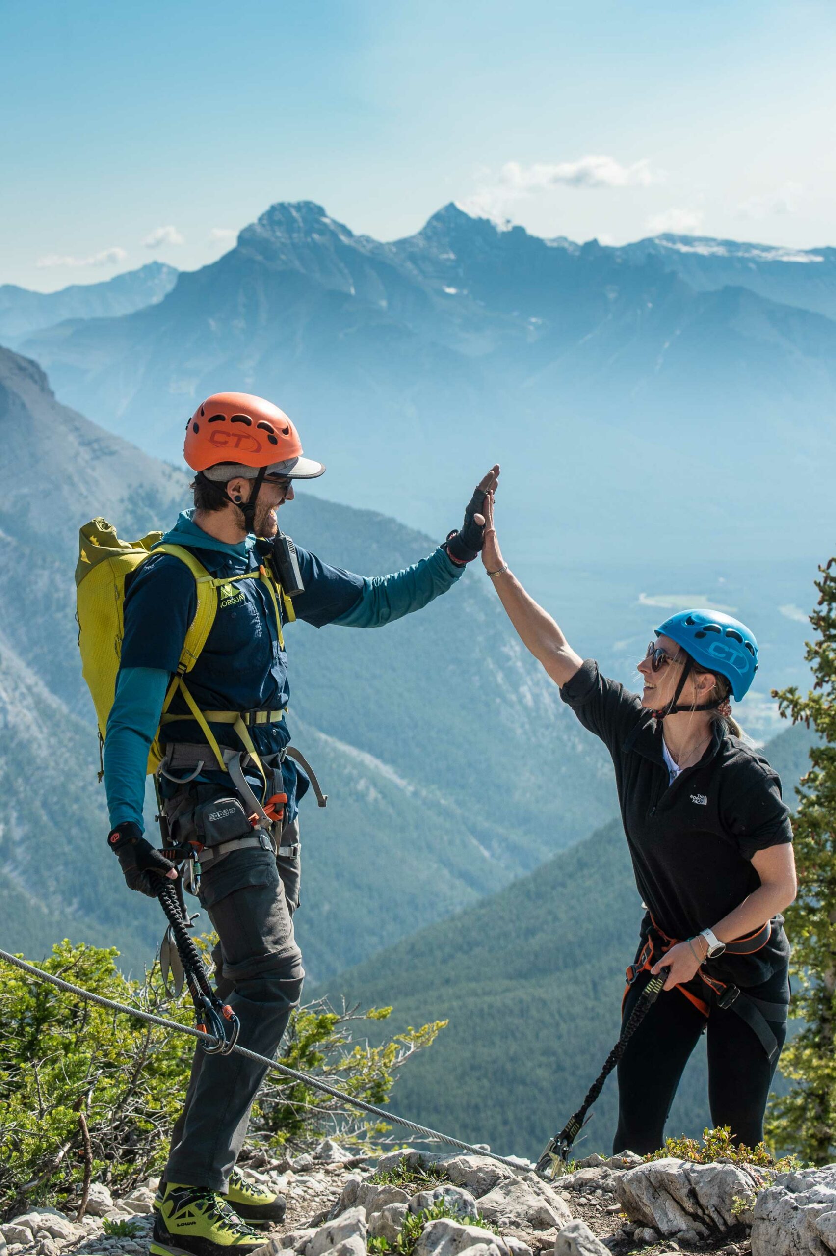 Two people high five while on the via ferrata at Mount Norquay