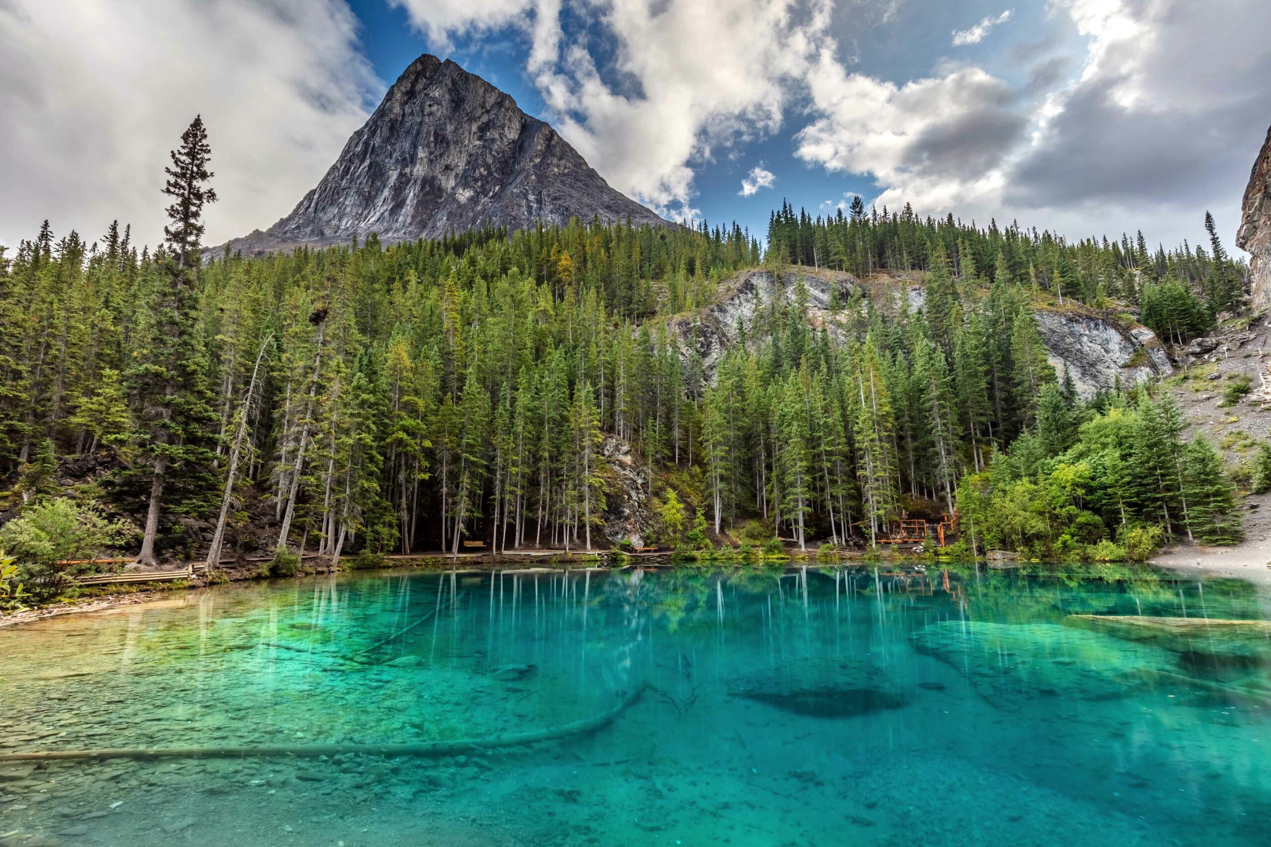 The beautiful, emerald-coloured Grassi Lakes in front of a mountain backdrop. This is a great, easy Kananaskis hike.