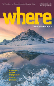 The cover of WHERE Canadian Rockies Winter 2023/2024 magazine features the masthead and a mountain reflecting in a frozen lake.