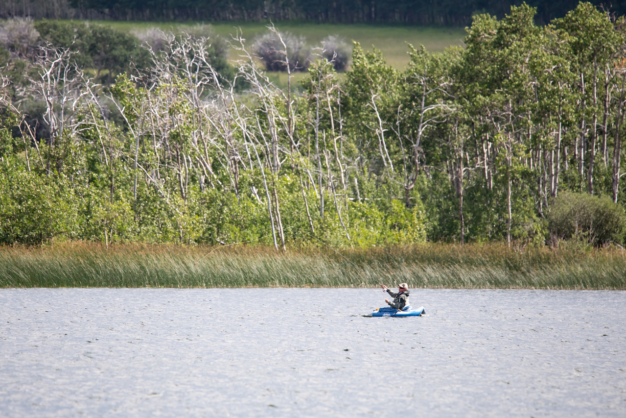 Fishing off a kayak on Outpost Lake in Police Outpost Provincial Park near Cardston in Southwestern Alberta