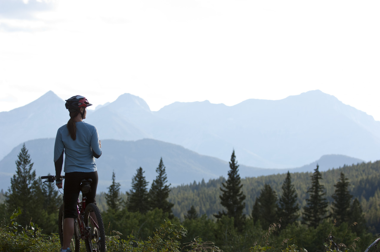 Woman looking at the view while mountain biking in Crowsnest Pass in Southwestern Alberta.