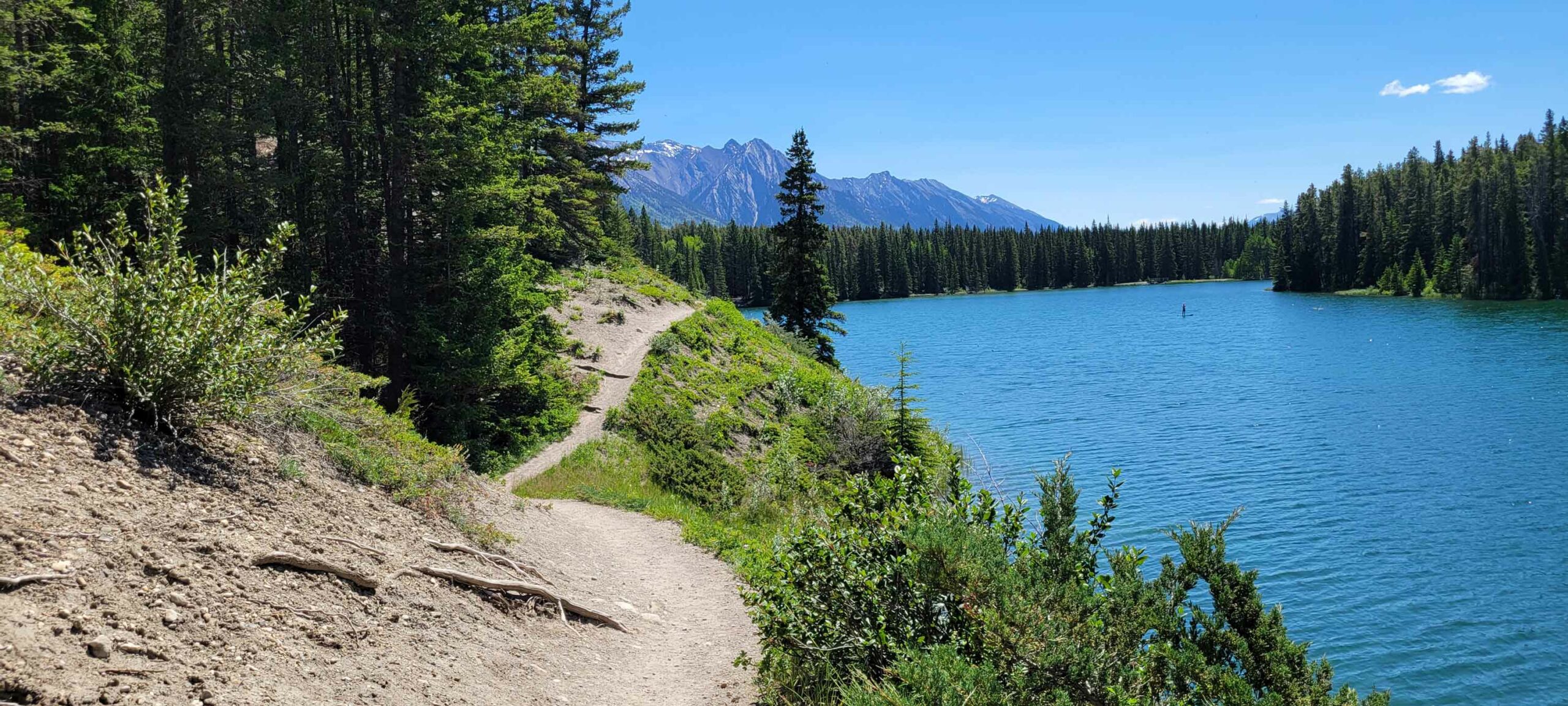 The Johnson Lake Trail along the lake with mountain views.