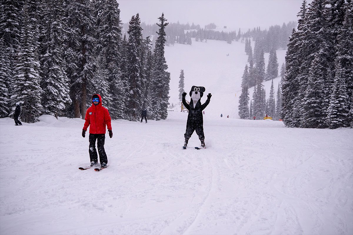 A skier at Marmot Basin with Jasper the bear.