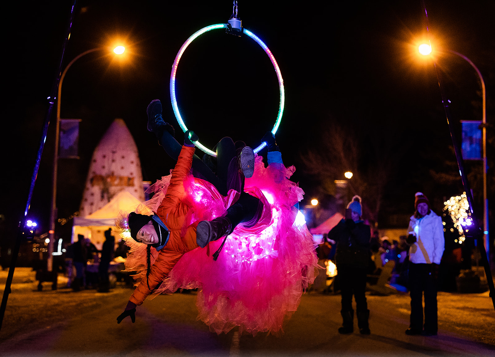 A hoop dancer street performer performs a trick outside at Jasper in January's Street Party.