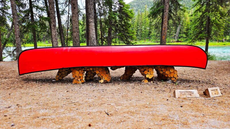 The BEAR-TAGE by Jason Carter on the Art in Nature Trail features an artistic representation of two bears carrying a red canoe along the Bow River. This trail is a great free activity to do when visiting Banff.