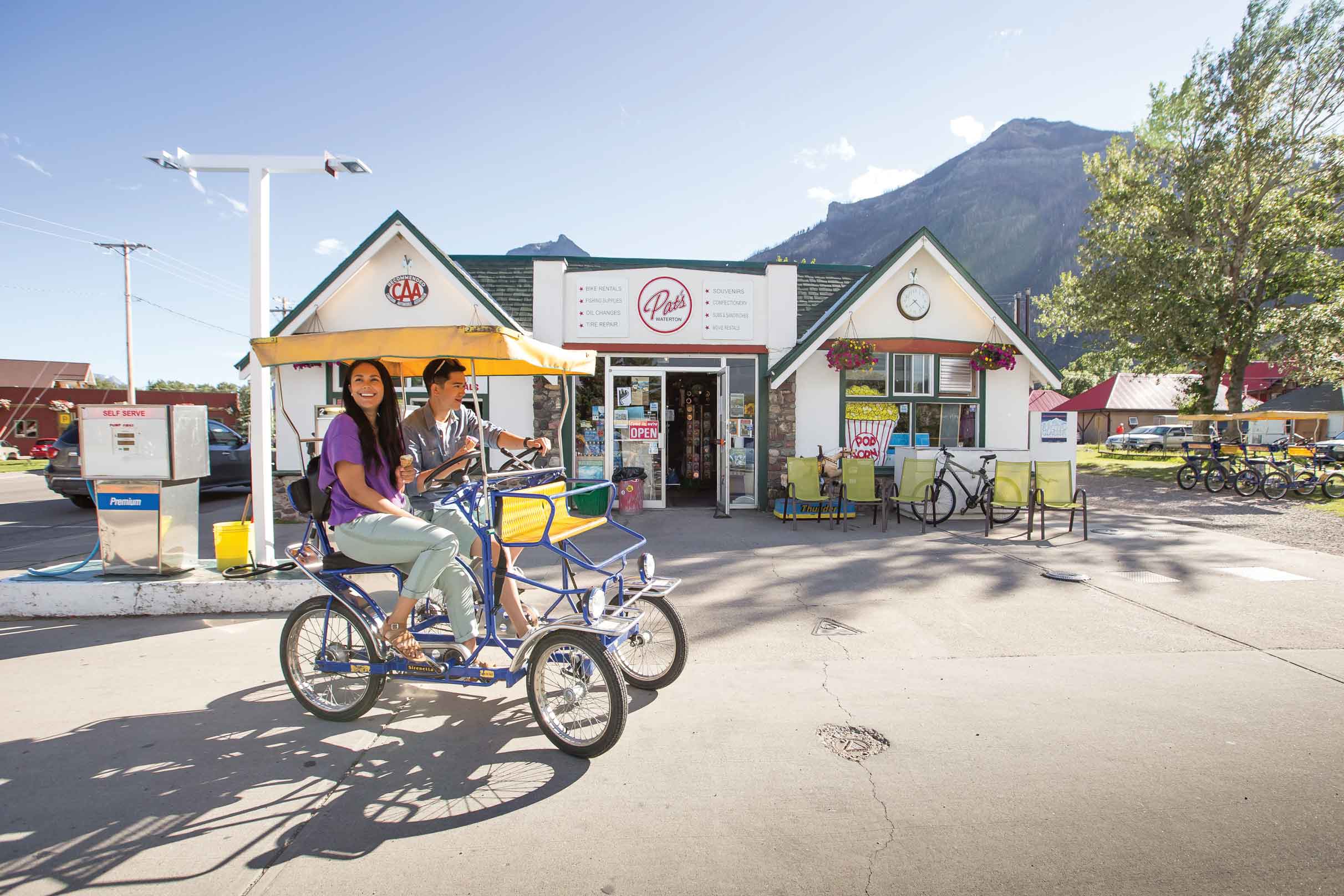 Two people on a Surrey bike in front of Pat's Waterton 