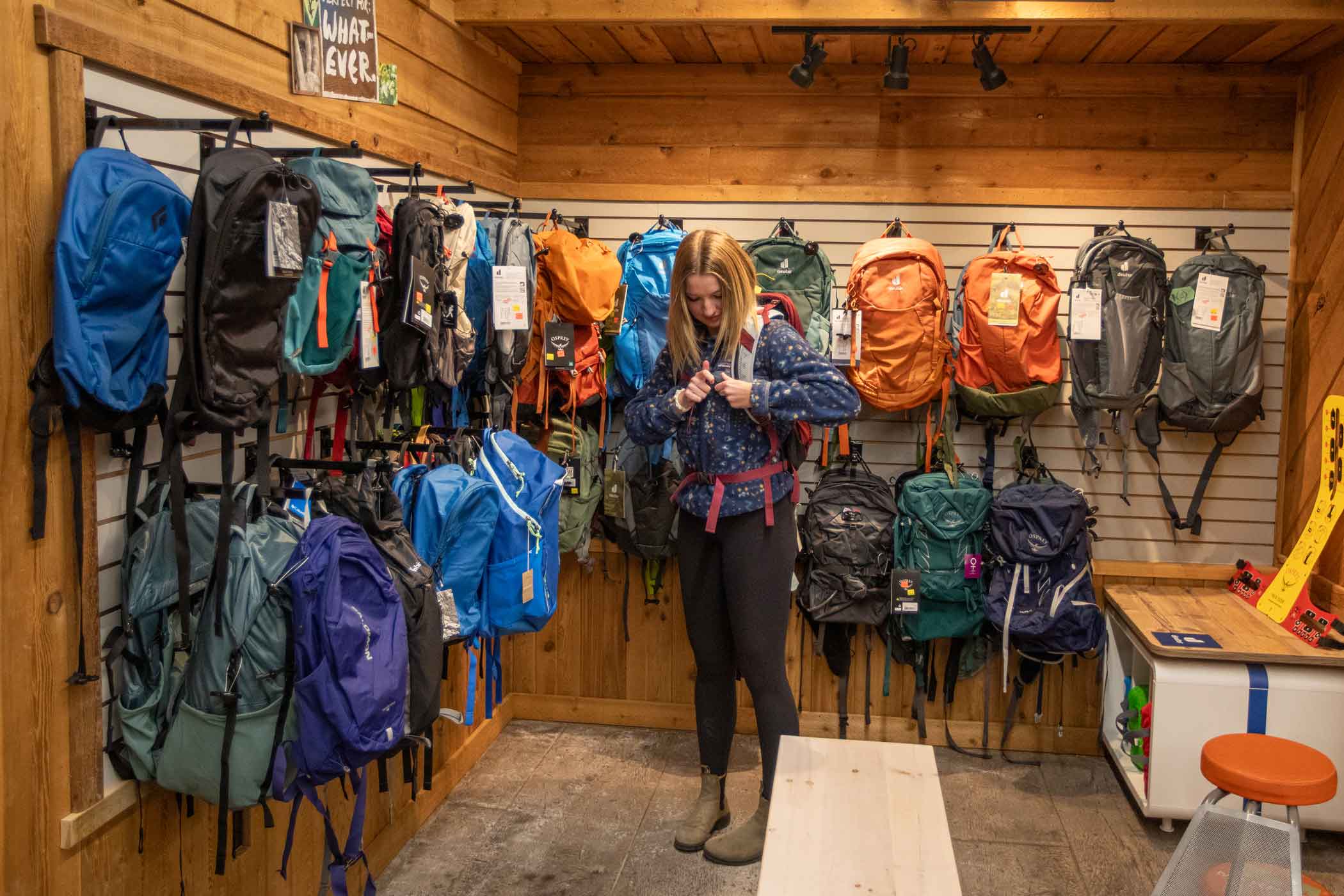 A hiker tries on a backpack at Tamarack Outdoors in Waterton
